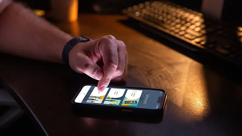 Hand bedient Somfy Smart-Home-App auf Smartphone – automatische Storen-Steuerung per App
